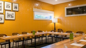 A conference room with a long table, chairs, framed pictures on the wall, a window, and a lamp. - The Cally Hotel (Warrnambool)