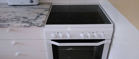 A kitchen with a white stove, oven, and a toaster on the countertop.