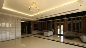 A spacious lobby with a high ceiling, a chandelier, and two sofas. - Yu Chun Hotel (Taichung)