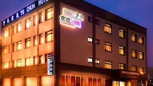 A hotel with multiple floors, illuminated signage, and a series of windows. - Yu Chun Hotel (Taichung)