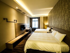 A hotel room with two beds, a desk, a TV, and a patterned wall. - Yu Chun Hotel (Taichung)
