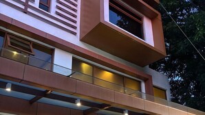 Un bâtiment moderne à plusieurs étages, doté de grandes fenêtres et d’un espace extérieur aménagé pour s’asseoir.