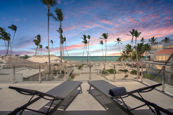 A beachside resort with lounge chairs and a view of the ocean.