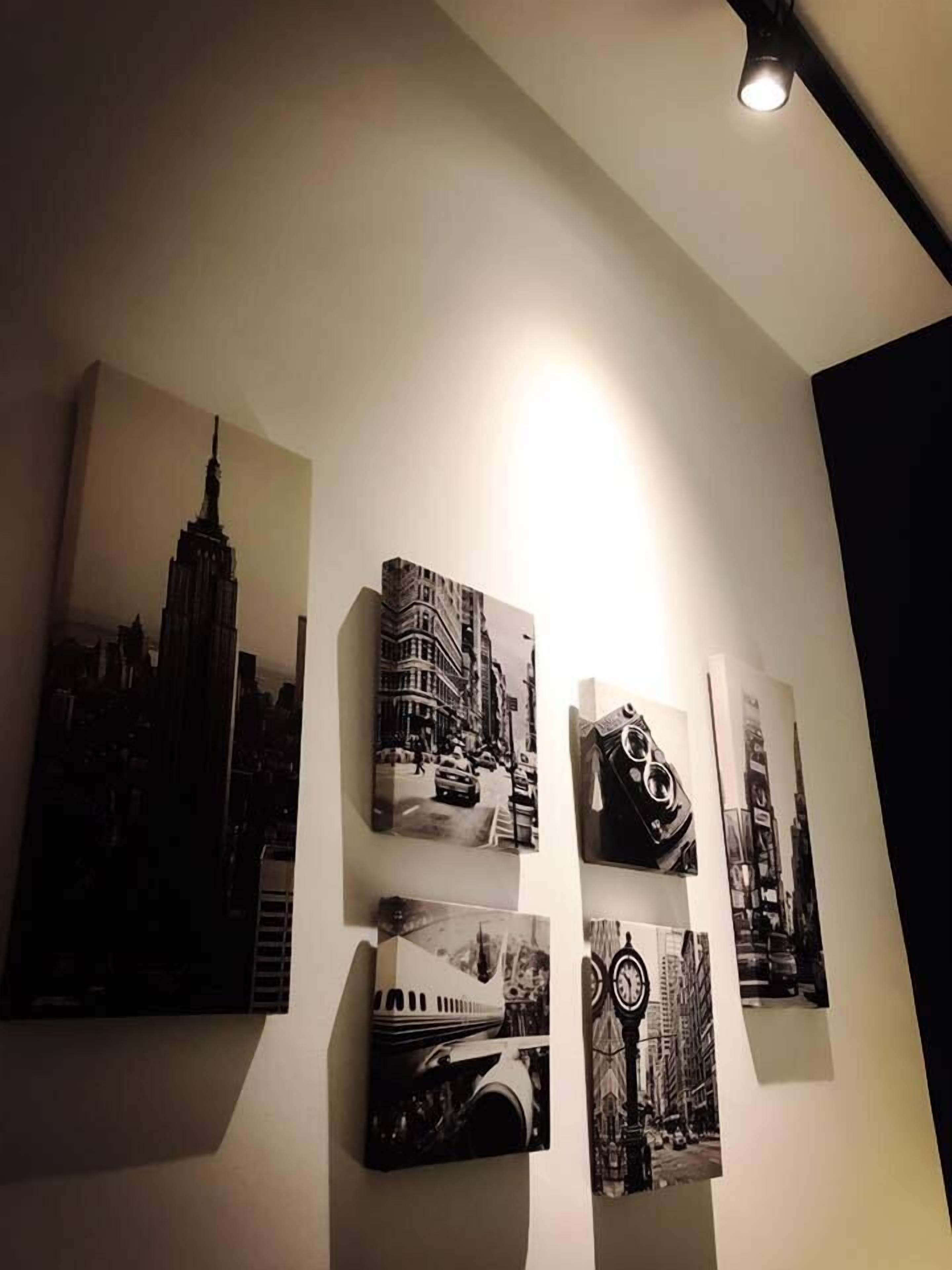 A wall with five black and white photographs of cityscapes and architectural structures.