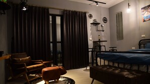 A modern bedroom with a bed, a leather sofa, a small round table, and a chair. - Living house (Hengchun)