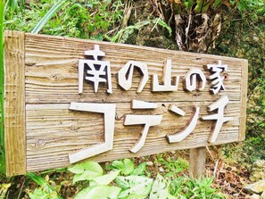 A wooden sign with Japanese characters. - Private Lodge COTENCHI (Nakijin)