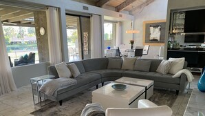 A modern living room with a sectional sofa, a coffee table, and a TV.