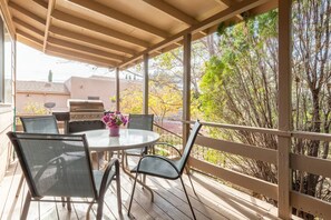 An outdoor patio with a round table, four chairs, and a grill. - The Lovely House in the Heart of Sedona (Sedona)