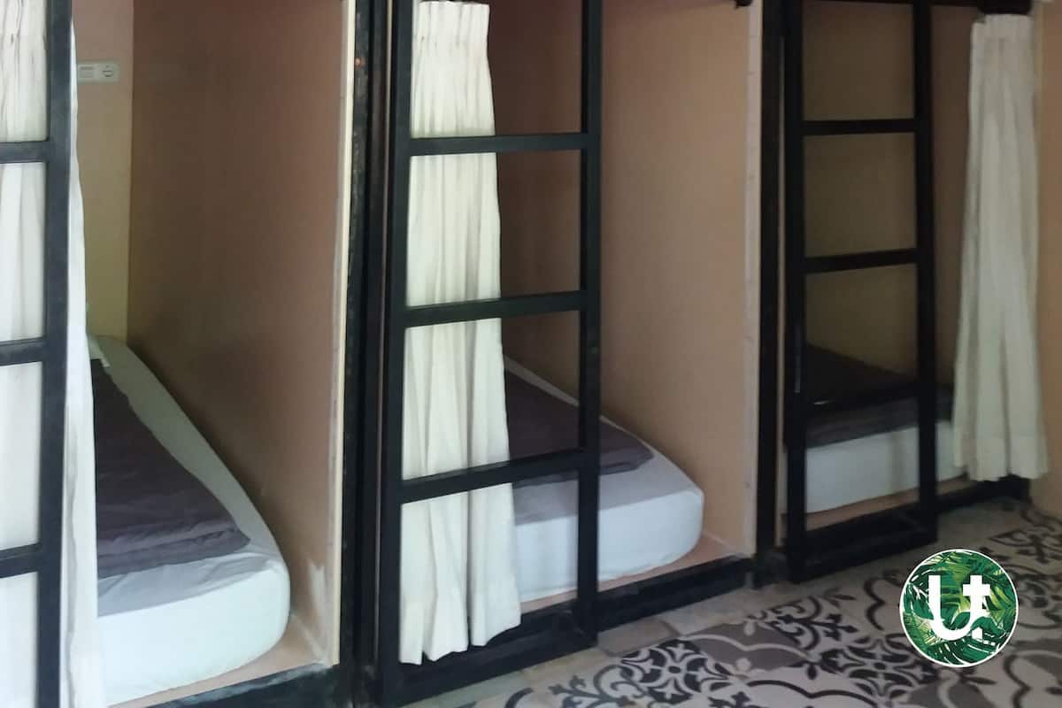 Habitación con literas, cortinas y piso estampado.