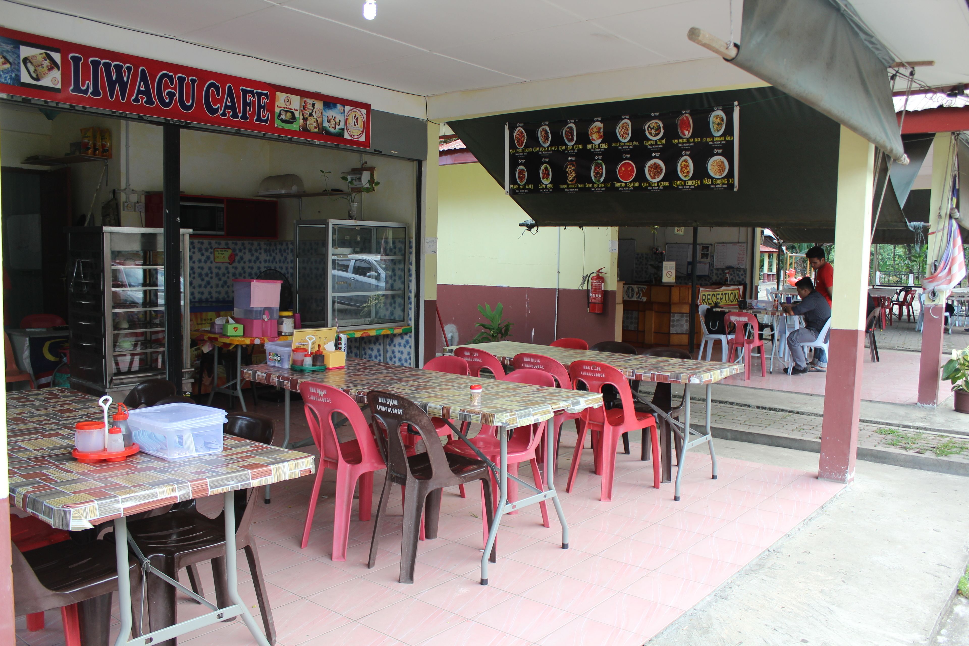 A cafe with outdoor seating, a menu board, and a sign reading "LIWAGU CAFE".