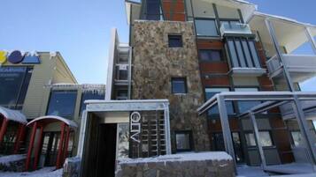 A multi-story hotel with a stone facade, balconies, and a sign for 'DOMINABLE'.