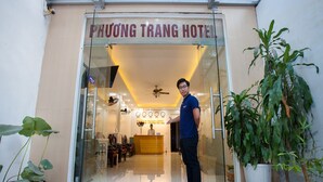 Der Eingang des Phuong Trang Hotels mit einer Rezeption, Stühlen und einem Deckenventilator.