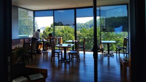 Amplio espacio interior con grandes ventanales que ofrecen vistas a un paisaje verde exuberante.