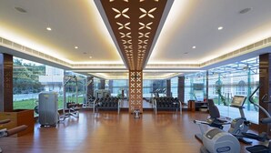 Un gimnasio amplio con máquinas de cardio, bancos de pesas y mancuernas.