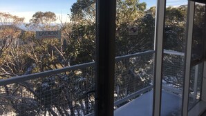 Une vue depuis une fenêtre, sur laquelle on peut voir une enseigne indiquant « LACROIX SPORTWEAR » et un panneau « Il est interdit de fumer ».