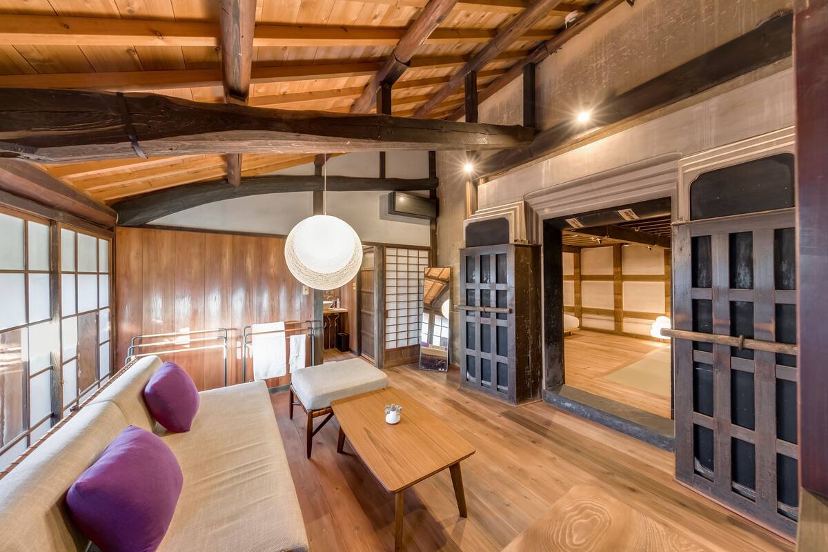 Ein traditioneller japanischer Raum mit Tatami-Böden, einer niedrigen Holzbalkendecke und Schiebetüren.
