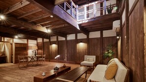 Un intérieur rustique avec un plancher en bois, un canapé, une table et un balcon offrant une vue agréable.