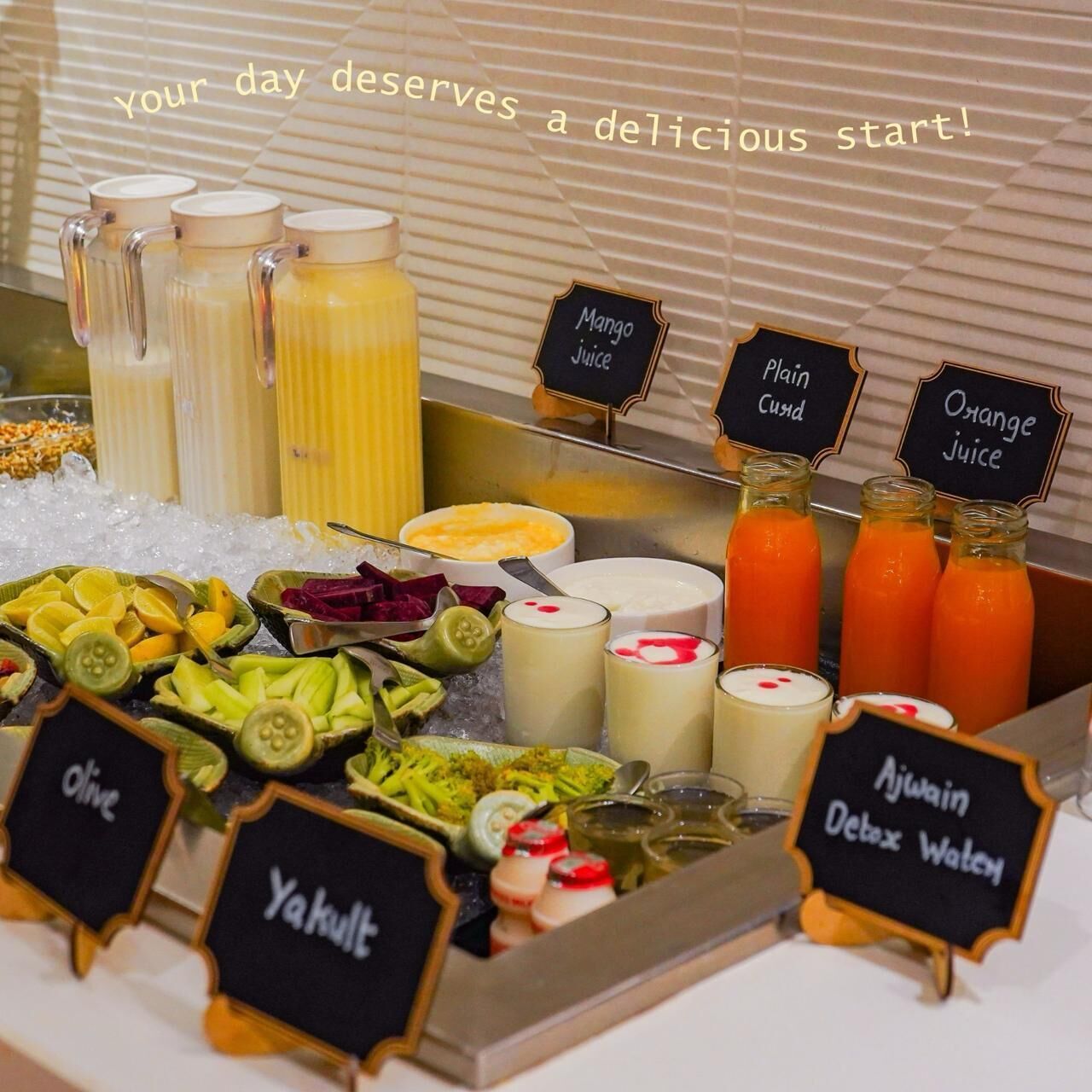 A breakfast buffet with various juices, yogurts, and fruits.