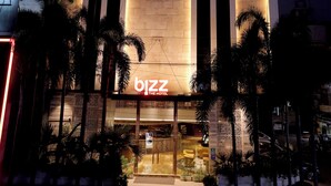 A hotel named 'bizz' with a modern facade, large windows, and a well-lit entrance. - Bizz The Hotel (Rajkot)