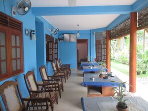 A room with blue walls, wooden furniture, and a view of greenery outside. - New Blue Home (Ella)