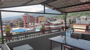 A balcony with a view of a cityscape and mountains. - Harry Guest House & Restaurant (Pokhara)