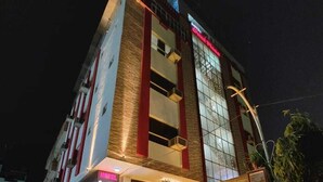 A multi-story hotel with a modern facade, featuring a prominent entrance with illuminated steps and potted plants. - Omni Plaza (Jodhpur)