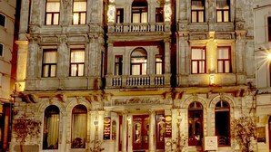 A multi-story hotel with a classic architectural style, featuring balconies and ornate detailing. - Grand Hotel de Londres (Istanbul)