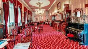 A grand room with ornate chandeliers, red patterned carpet, and classic furniture. - Grand Hotel de Londres (Istanbul)