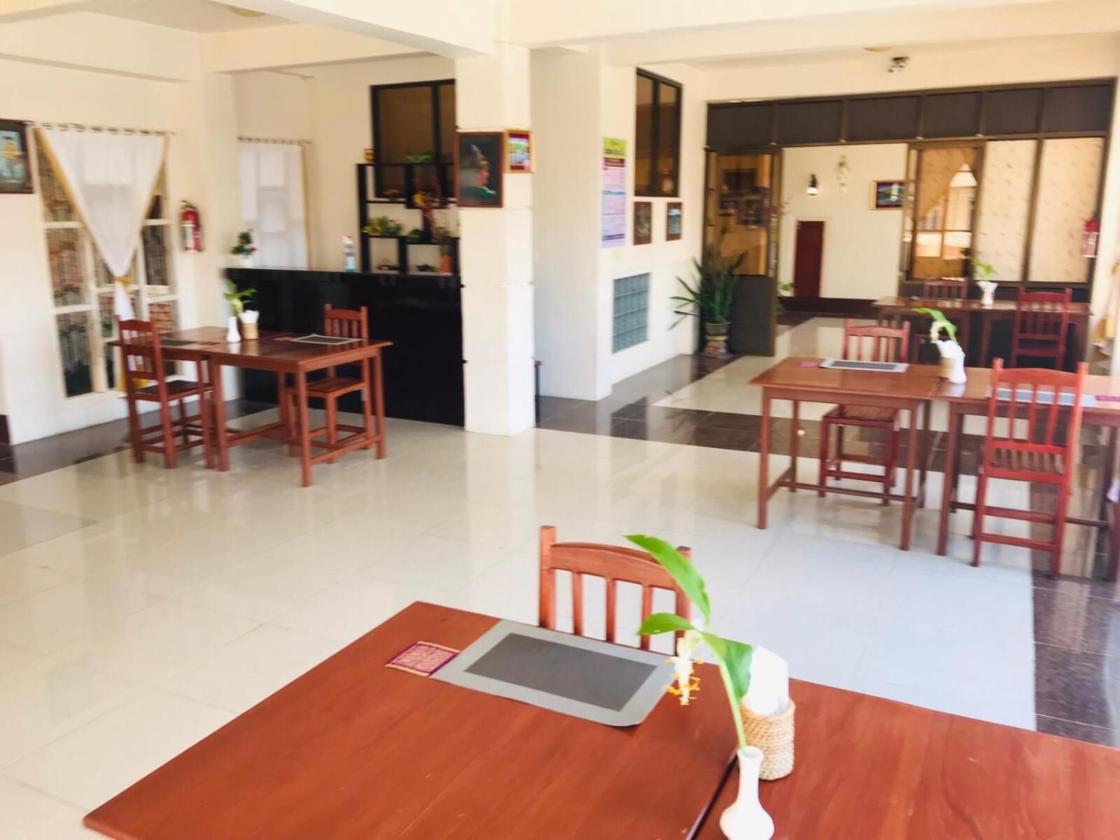 Una hall d'albergo con arredi in legno, una reception e un pavimento piastrellato.