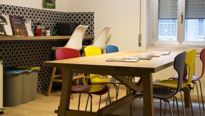 A dining area with a wooden table and colorful chairs. - 1970 Rooms (Naples)