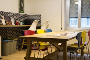 Un comedor con una mesa de madera y sillas coloridas.