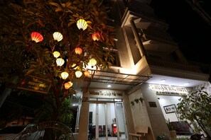 Vista frontal de la propiedad por la tarde o noche