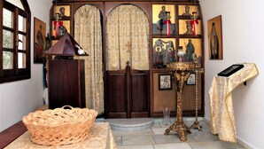 Ein religiöses Ikonostase mit religiösen Ikonen, ein hölzernes Lesepult und ein gewebter Korb.