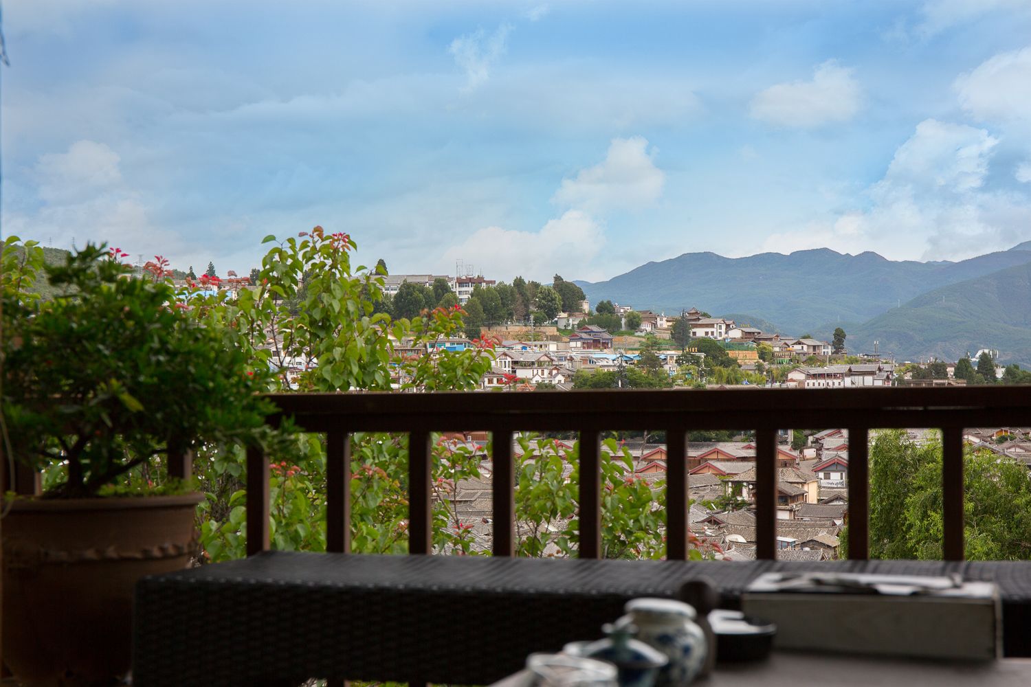A balcony with a view of a town and mountains.