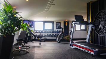 A gym with exercise equipment, including treadmills and dumbbells.