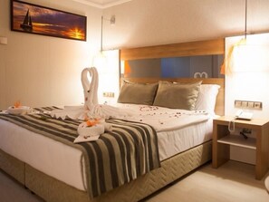 Une chambre d’hôtel avec un lit, une table de chevet, une lampe et un tableau au mur.