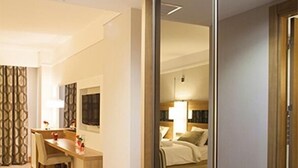 Une chambre d’hôtel équipée d’un bureau, d’une chaise, d’un lit et d’un miroir.