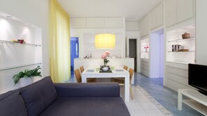 Un salon moderne avec un canapé, une table à manger et un téléviseur.