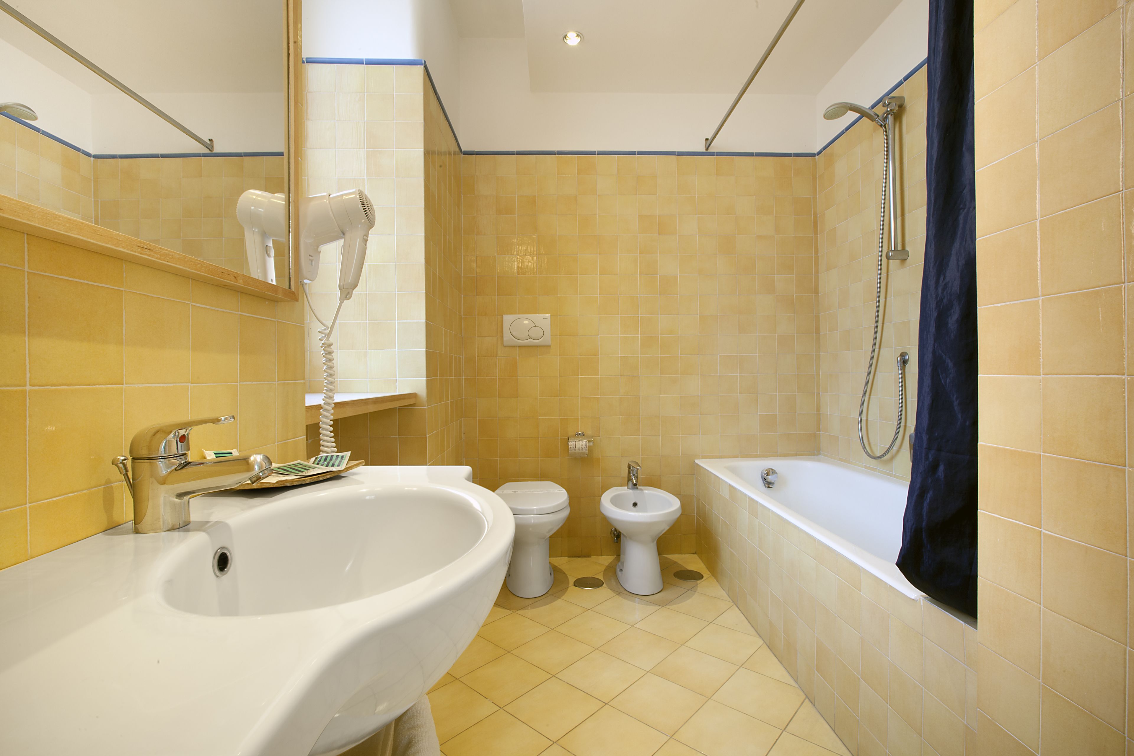 Une salle de bain équipée d’un lavabo, de toilettes, d’un bidet et d’une baignoire.