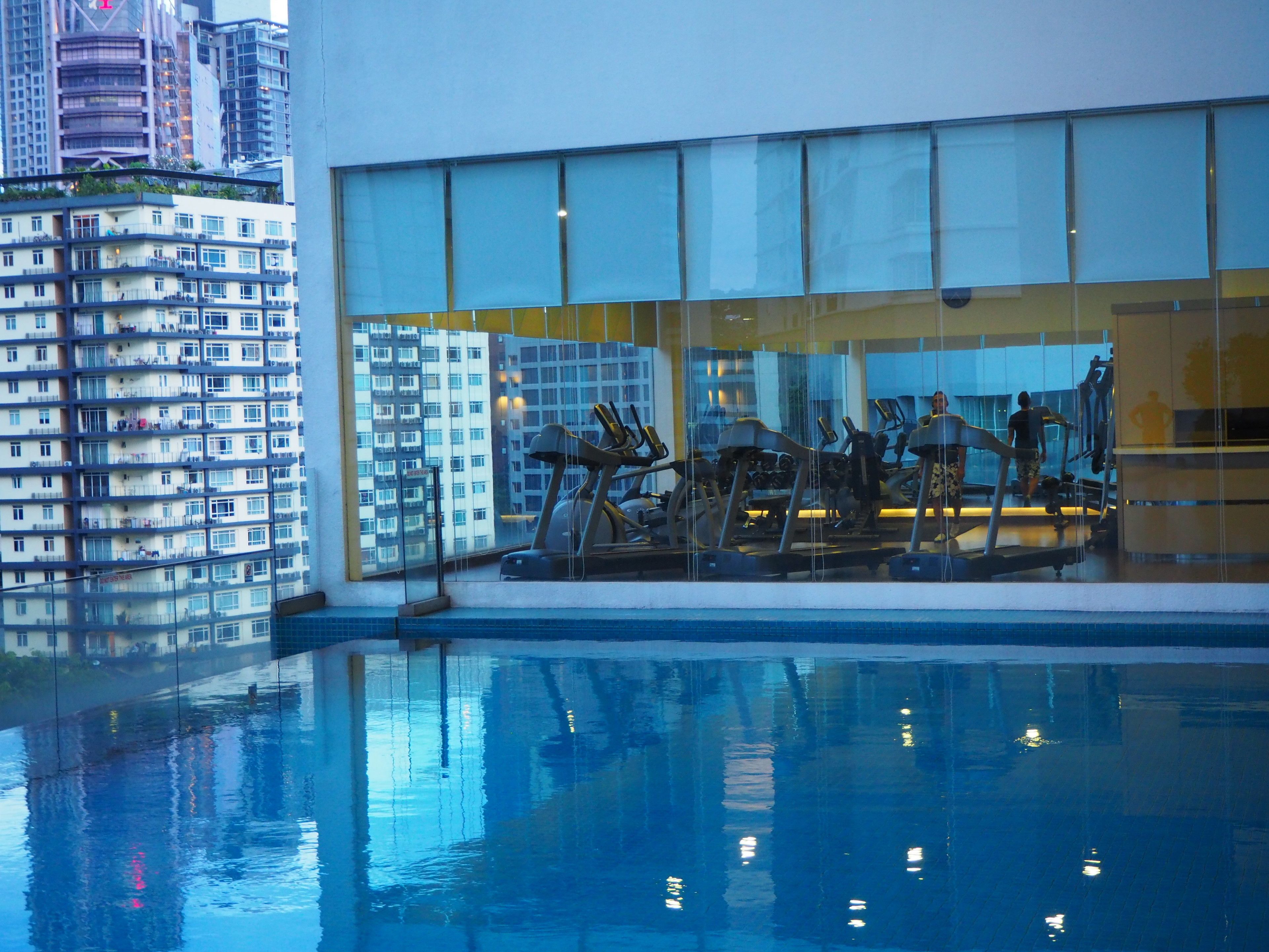 A modern building with a glass facade, a swimming pool, and exercise equipment.