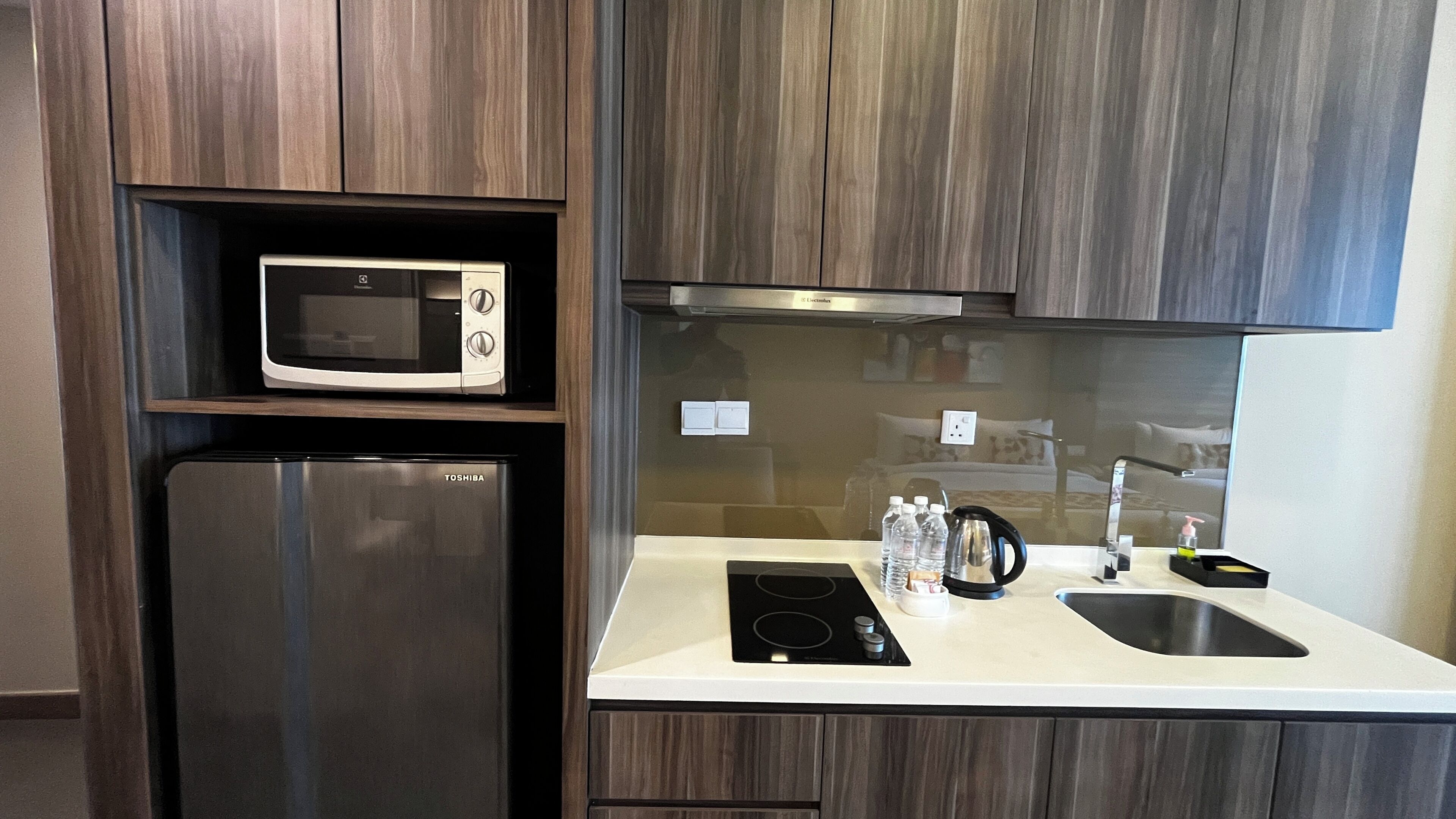 A kitchen with a microwave, refrigerator, stove, and sink.