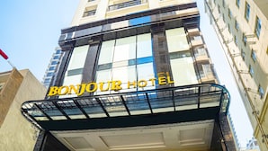 A hotel entrance with a glass facade, a sign reading "BONJOUR HOTEL", and a staircase leading to the entrance. - Bonjour Nha Trang Hotel (Nha Trang)