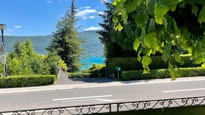 A sign reading "VILLA RIVA" with a view of a lake and mountains in the background. - Villa Riva (Veyrier-du-Lac)