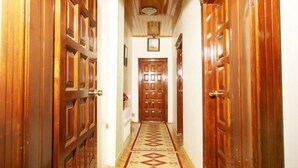 Un couloir avec des portes en bois et un tapis à motifs.