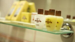 Une étagère de salle de bain contenant divers produits de toilette, notamment des flacons de shampoing et d’après-shampoing.