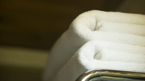 Une serviette blanche, pliée avec soin, est posée sur une surface recouverte de chrome.