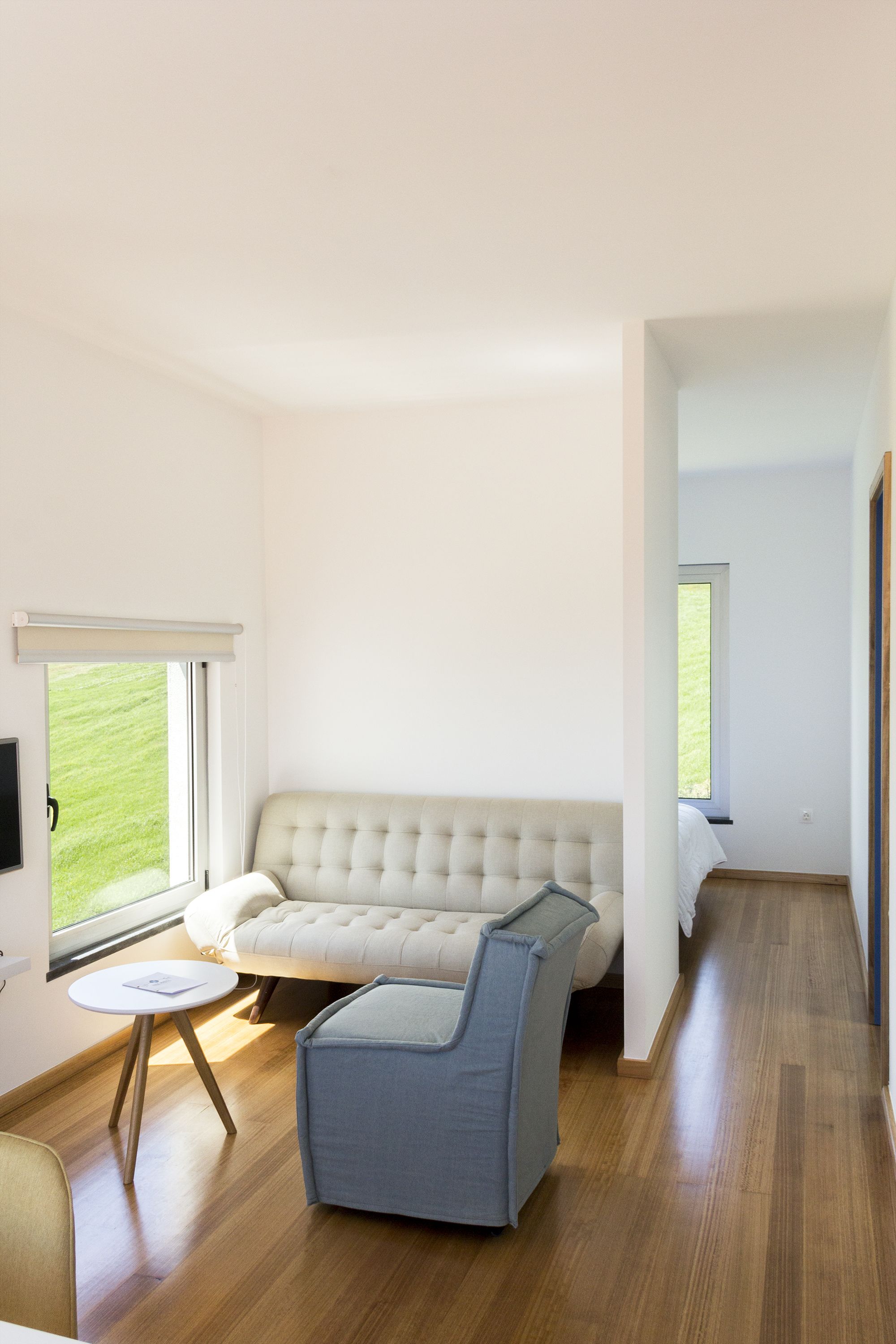 Una sala de estar moderna con un sofá, un sillón, una mesita y un televisor.