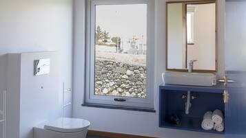 Un baño con inodoro, lavamanos y ventana.