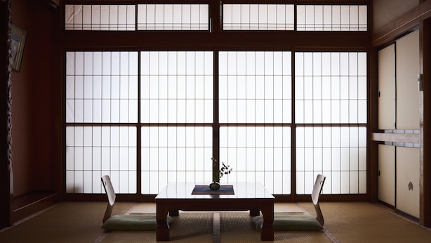 A traditional Japanese room with tatami flooring, a low wooden table, and shoji screens. - Tsukasaya Ryokan (Tsuruoka)