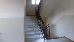 A staircase with a metal railing leading to a landing. - Kayegi Hotel (Mbale)